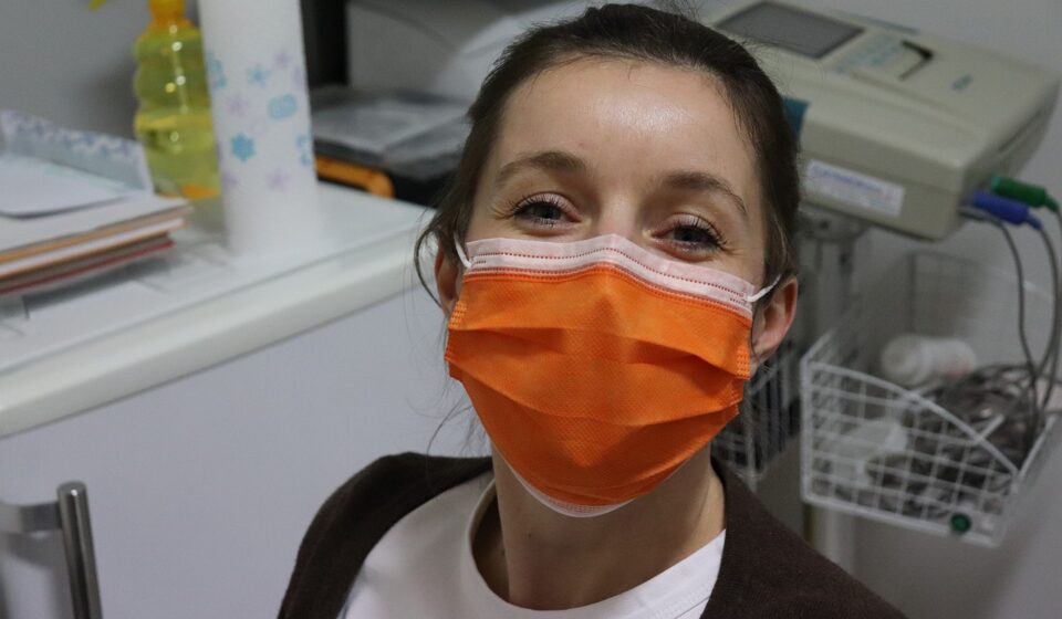 face mask, nurse, woman with mask, healthcare worker, orange mask, clinic, medical setting, safety, hospital, pandemic, protective gear, health professional, smiling eyes, female portrait, medical staff, friendly expression, covid-19, hygiene, healthcare environment, face protection, medical equipment, doctor, protective wear, indoor portrait